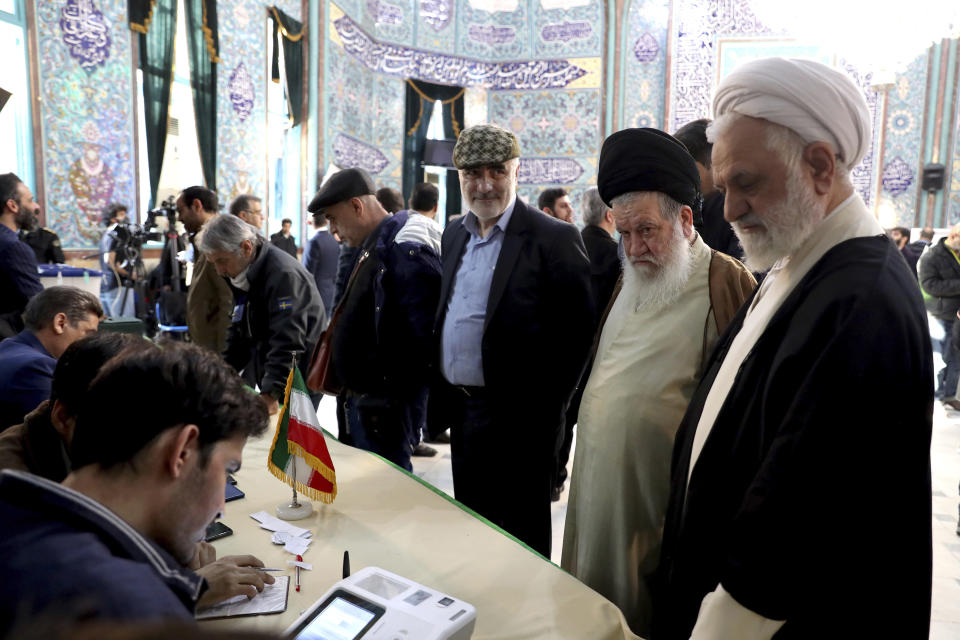 Voters register to cast their vote during the parliament elections at a polling station in Tehran, Iran, Friday, Feb. 21, 2020. Iranians began voting for a new parliament Friday, with turnout seen as a key measure of support for Iran's leadership as sanctions weigh on the economy and isolate the country diplomatically. (AP Photo/Ebrahim Noroozi)