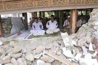 Survivors perform Friday prayer at a mosque badly damaged by Wednesday's earthquake in Pidie, Aceh province, Indonesia, Friday, Dec. 9, 2016. Over one hundred people were killed in the quake that hit the northeast of the province on Sumatra before dawn Wednesday. Hundreds of people were injured and thousands buildings destroyed or heavily damaged. (AP Photo/Heri Juanda)