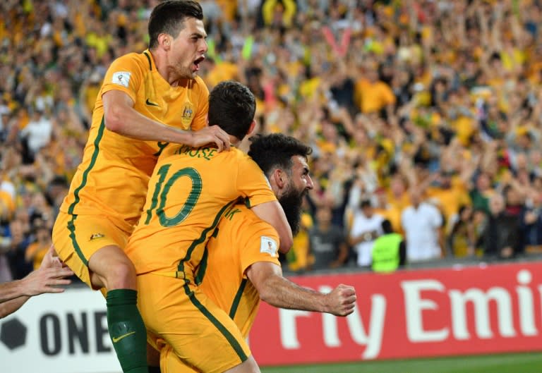 Australia's Mile Jedinak (R) is congratulated by teammates after scoring a goal against Honduras in their FIFA 2018 World Cup qualification play-off 2nd leg match, in Sydney, on November 15, 2017