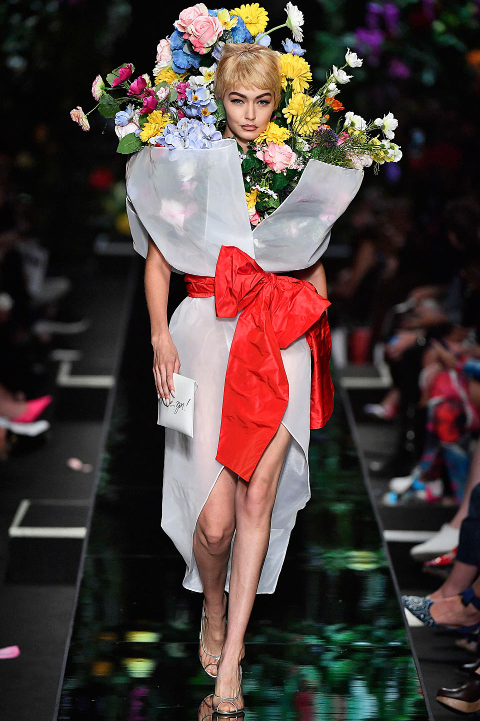 <p>The model rocked a blonde pixie and a massive bouquet of flowers on the Moschino runway.</p>
