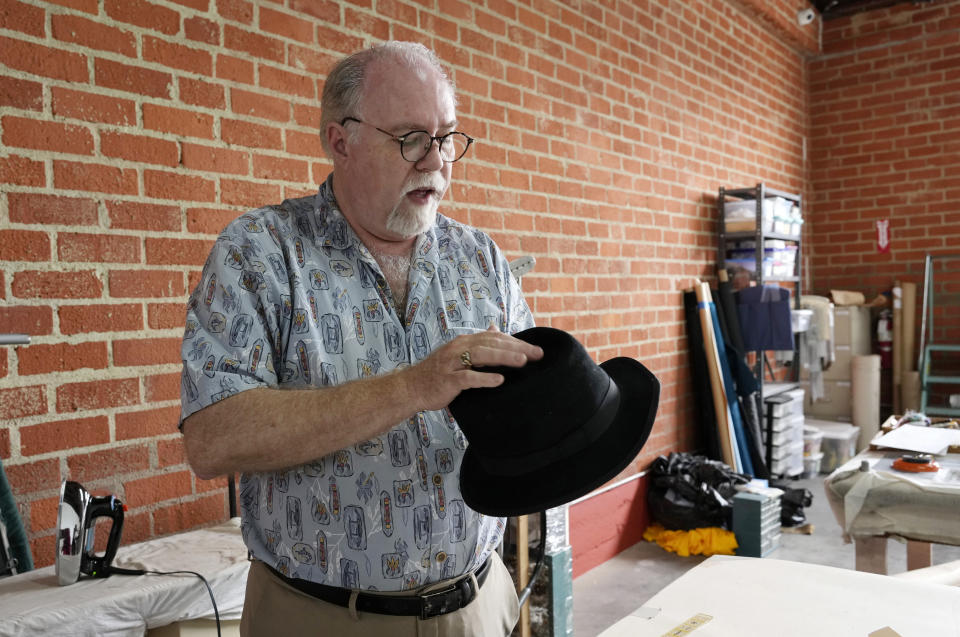 Shon LeBlanc, co-owner of costume rental service Valentino's Costume Group, primps a bowler hat at his warehouse, Friday, May 26, 2023, in Los Angeles. (AP Photo/Chris Pizzello)