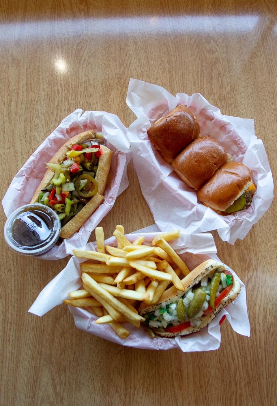 An Italian beef sandwich with hot and sweet peppers, a Chicago style hot dog with french fries and cheese sliders at Chicago Hamburger Company, Nov. 5, 2019.