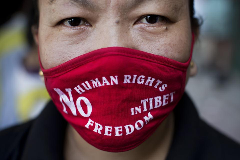 FILE - In this Sept. 17, 2014, file photo, an Exile Tibetan woman wears a mask during a protest to highlight Chinese control over Tibet, coinciding with the visit of Chinese President Xi Jinping in New Delhi, India. A top Chinese leader has called for "advancing anti-separatism efforts" in Tibet, in a sign of continued high-pressure tactics in ruling the Himalayan region. (AP Photo/Bernat Armangue, File)