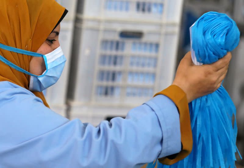 A woman wearing a protective face mask works in a factory that produces sterilised surgical equipment and medical clothings in Egypt