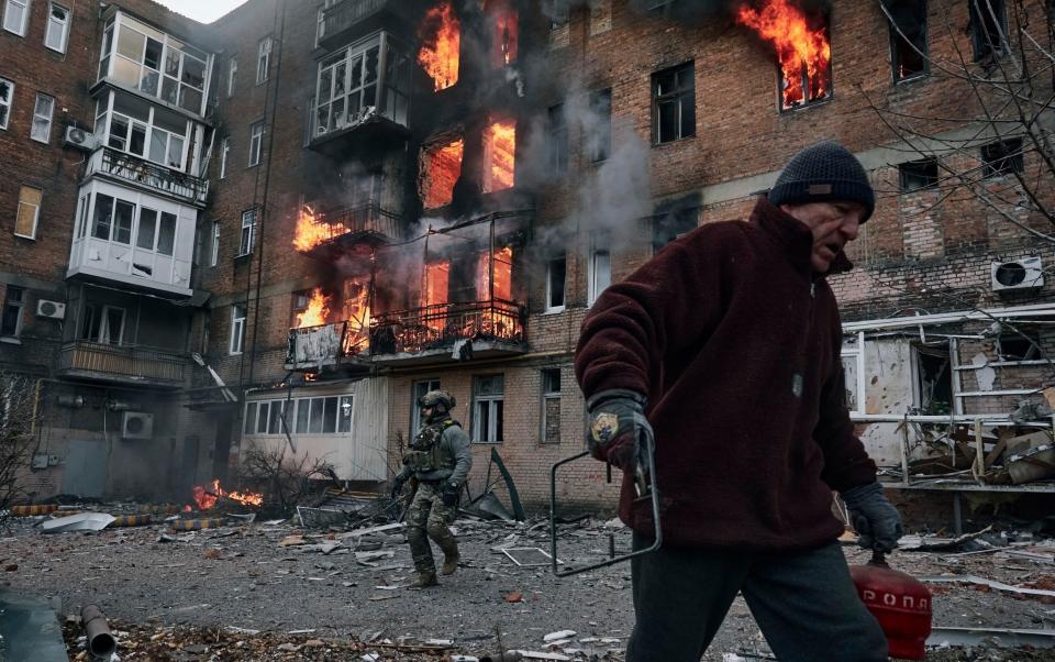 A local resident leaves his home after Russian shelling destroyed an apartment house in Bakhmut, Donetsk region - AP