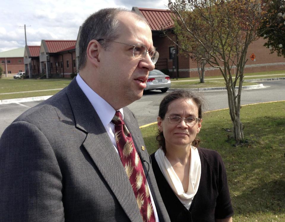 Alma and Christine Wetzker talk with reporters at Fort Stewart, Ga., after their son-in-law, Pvt. Isaac Aguigui, accused of strangling his pregnant wife 24-year-old Sgt. Deirdre Aguigui so he could pocket $500,000 in benefit money, was convicted Thursday, March 27, 2014, by a military judge in a case that hinged on dueling medical experts who couldn’t agree on how the woman died. (AP Photo/Russ Bynum)