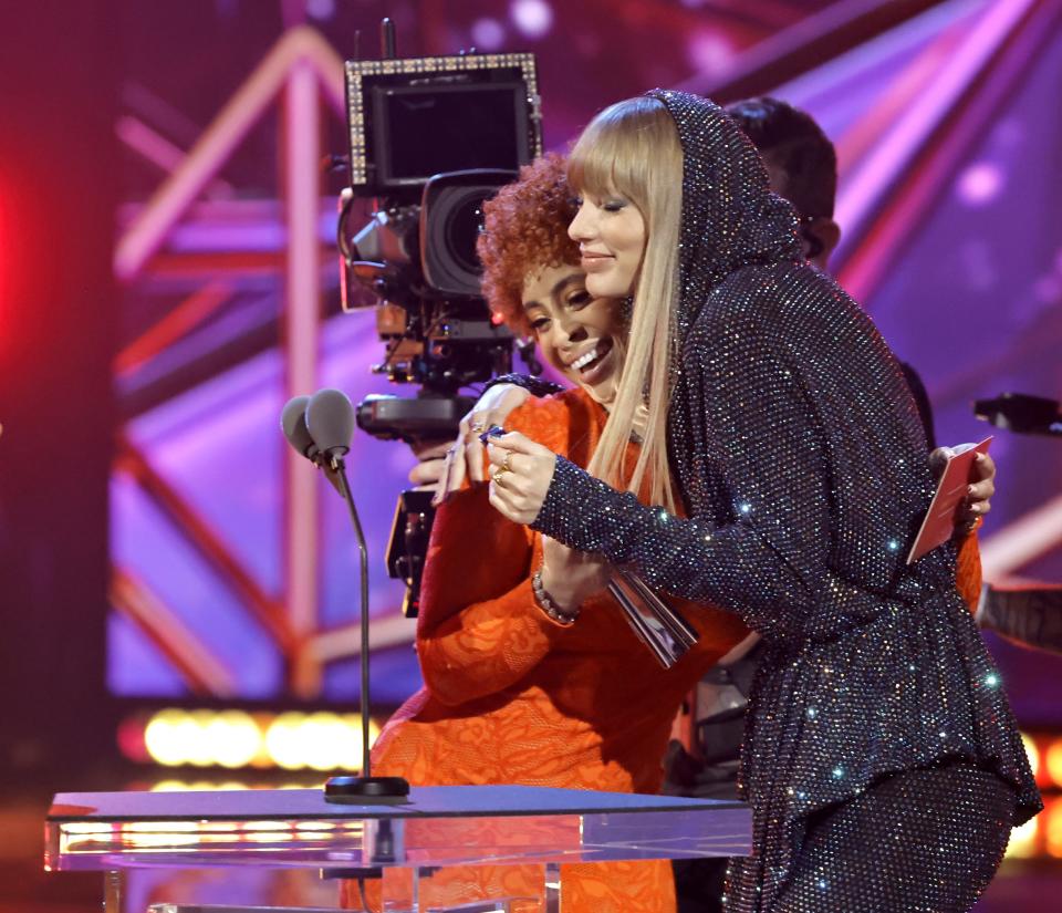 Tyler hugging Ice Spice at a podium