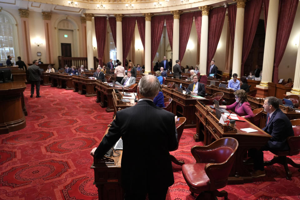 State Sen. Roger Niello, R-Fair Oaks, vice chairman of the Senate Budget and Fiscal Review Committee, back to camera, urges lawmakers to reject a measure to reduce the state budget deficit at the Capitol in Sacramento, Calif., Thursday, April 11, 2024. Calling it crisis budgeting with optimism Niello and other Republican lawmakers say the bill only delays dealing with the budget deficit. Both houses approved the bill that takes a number of steps to reduce the state budget deficit by about $17 billion. Gov. Gavin Newsom has said the deficit is about $38 billion.(AP Photo/Rich Pedroncelli)