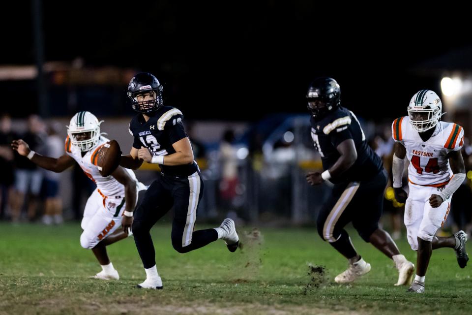 Buchholz Bobcats quarterback Trace Johnson (12) scrambles to throw the ball during the first half against the Eastside Rams at Citizens Field in Gainesville, FL on Friday, September 8, 2023. [Matt Pendleton/Gainesville Sun]