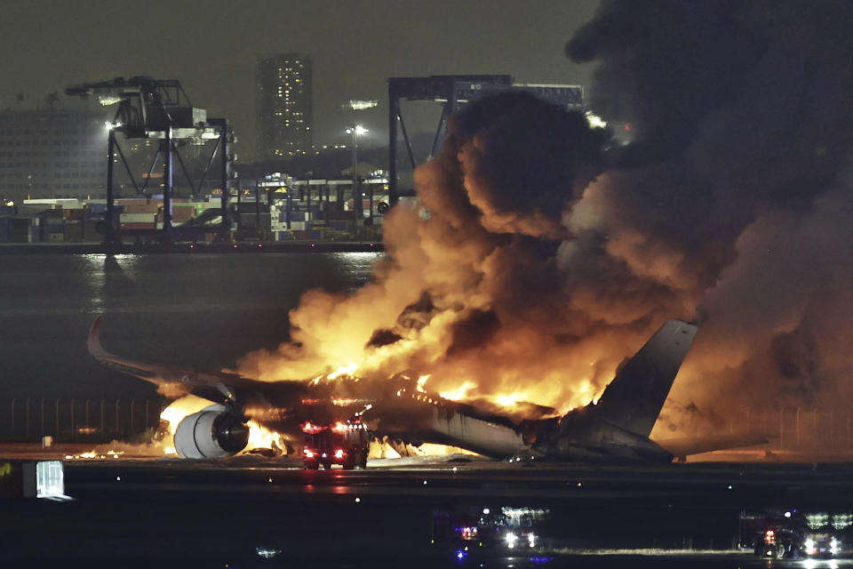 FILE - A Japan Airlines plane is on fire on the runway of Haneda airport in Tokyo, on Jan. 2, 2024. The 379 passengers of Japan Airlines Flight JAL-516 didn't expect their plane to burst into flames just as it was about to touchdown at Tokyo’s Haneda airport Tuesday evening. A smaller coast guard Bombardier Dash-8 aircraft, preparing to take off to deliver urgent aid to quake-hit central Japan, was using the same runway when the two collided. The Associated Press collected accounts from witnesses, officials and transcripts of the traffic controls communication. (Kyodo News via AP, File)