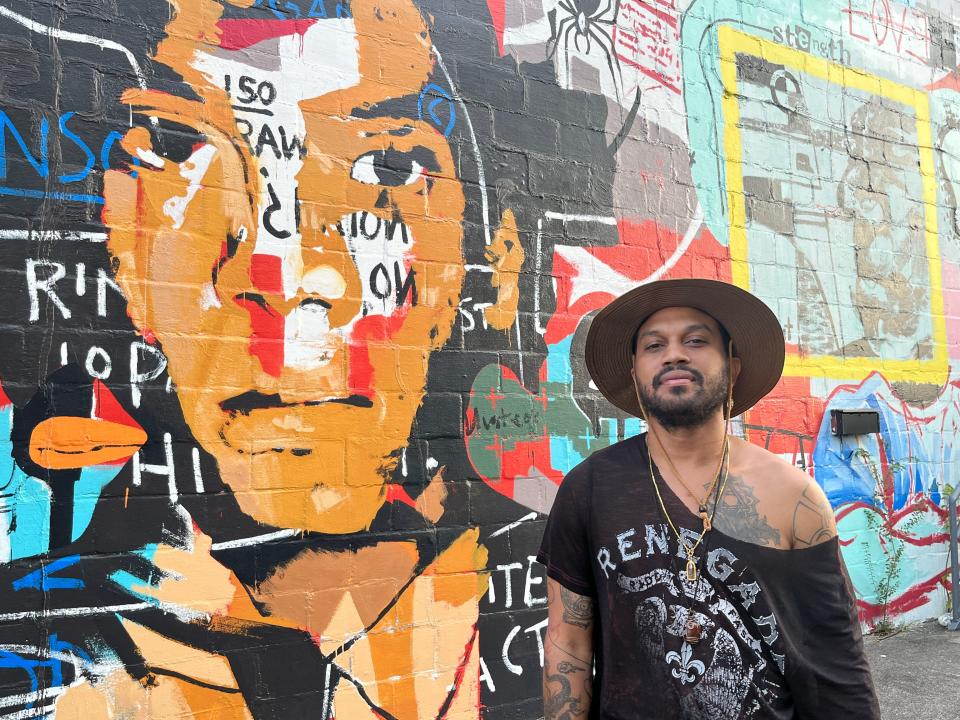 Aort Reed poses for a portrait in front of his mural "The Big Idea" on 11th Street in downtown Augusta on Wednesday, Aug. 23, 2023.