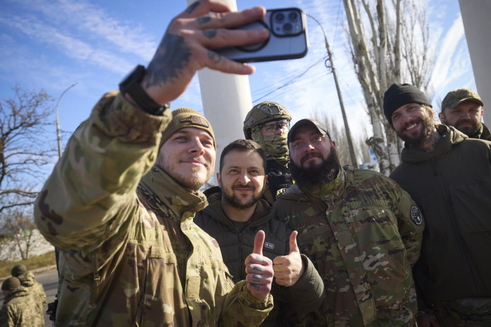 In this photo provided by the Ukrainian Presidential Press Office and posted on Facebook, Ukrainian soldiers take a selfie with President Volodymyr Zelenskyy, center, in Kherson, Ukraine, November 14, 2022. / Credit: Ukrainian Presidential Press Office/AP