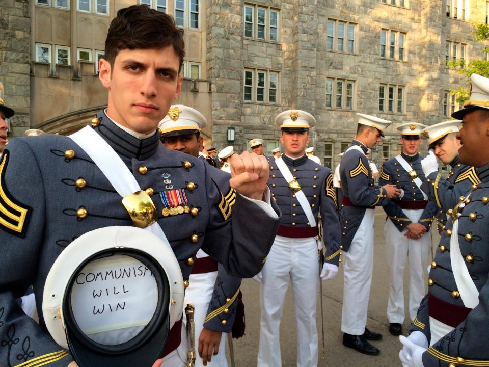 Spenser Rapone raises his left fist while showing a sign in a hat's inside after graduating from the US Military Academy at West Point: AP