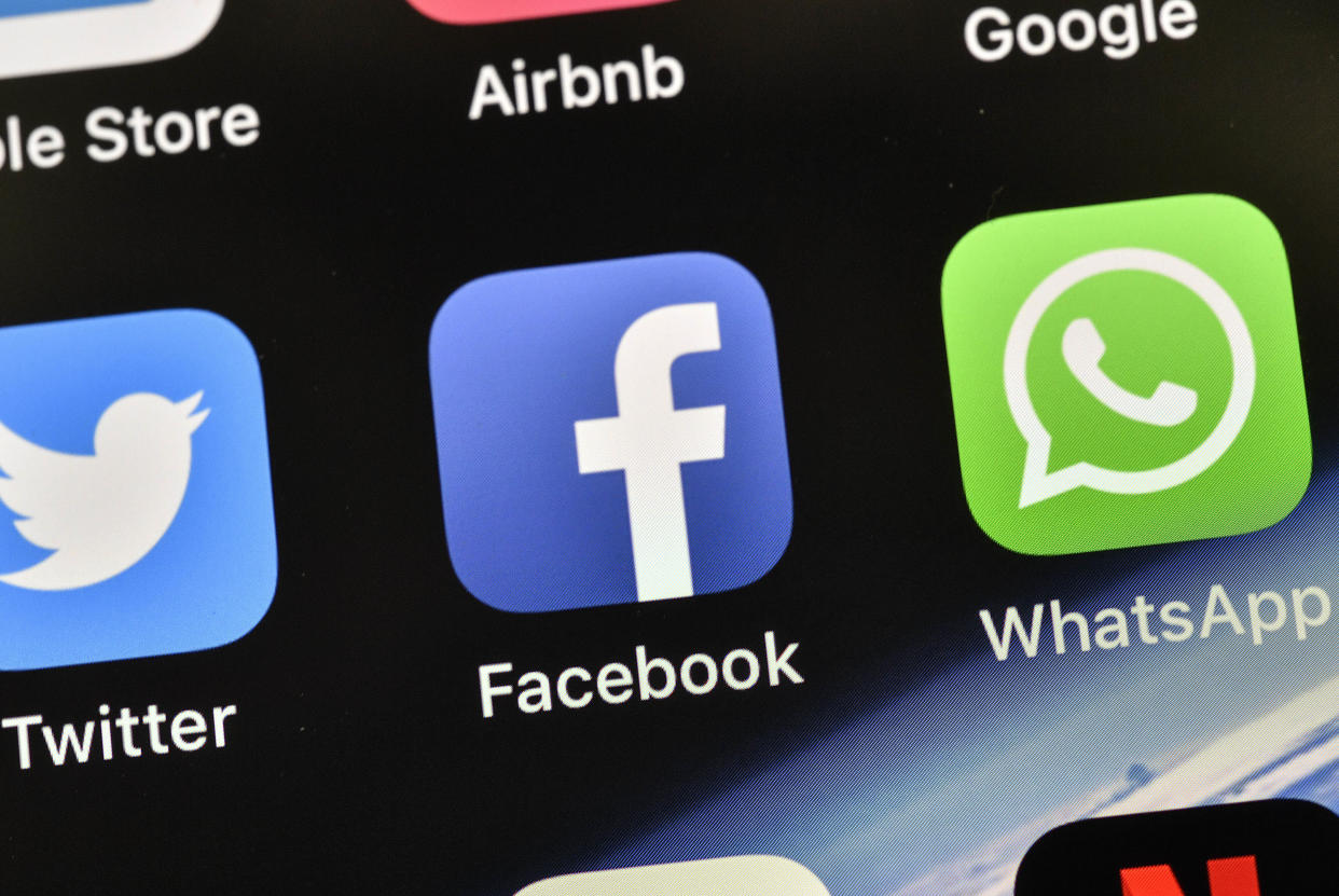 The icons of Facebook and WhatsApp are pictured on an iPhone on Thursday, Nov. 15, 2018 in Gelsenkirchen, Germany. (AP Photo/Martin Meissner)