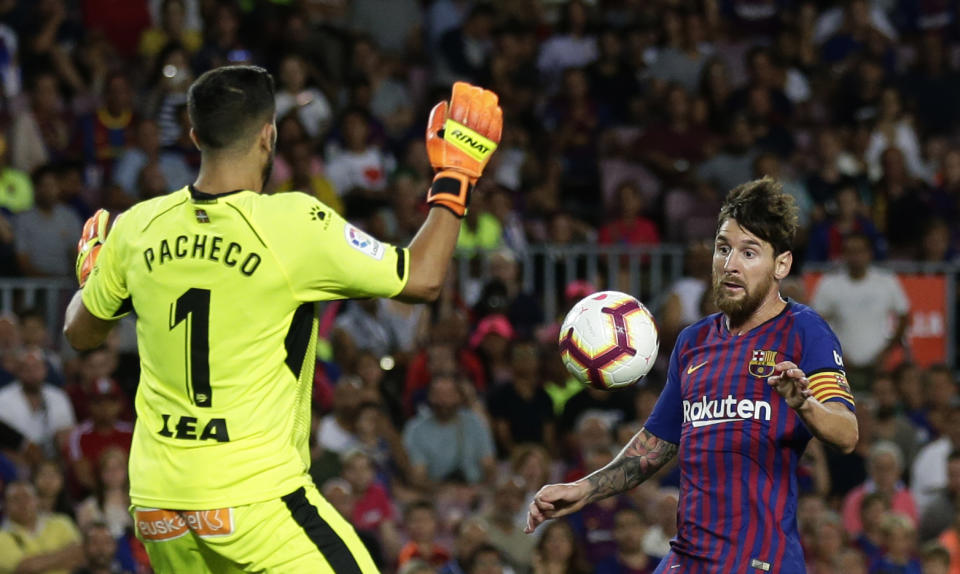FC Barcelona's Lionel Messi, right, vies for the ball against Alaves goalkeeper Pacheco during a Spanish La Liga soccer match at Camp Nou stadium in Barcelona, Spain, Saturday, Aug. 18, 2018. (AP Photo/Manu Fernandez)