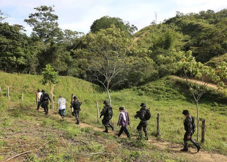 Prison guards escort inmates, who are looking for a pit, as they walk in a rural area close to Chaguani, Colombia, June 18, 2015. REUTERS/Jose Miguel Gomez