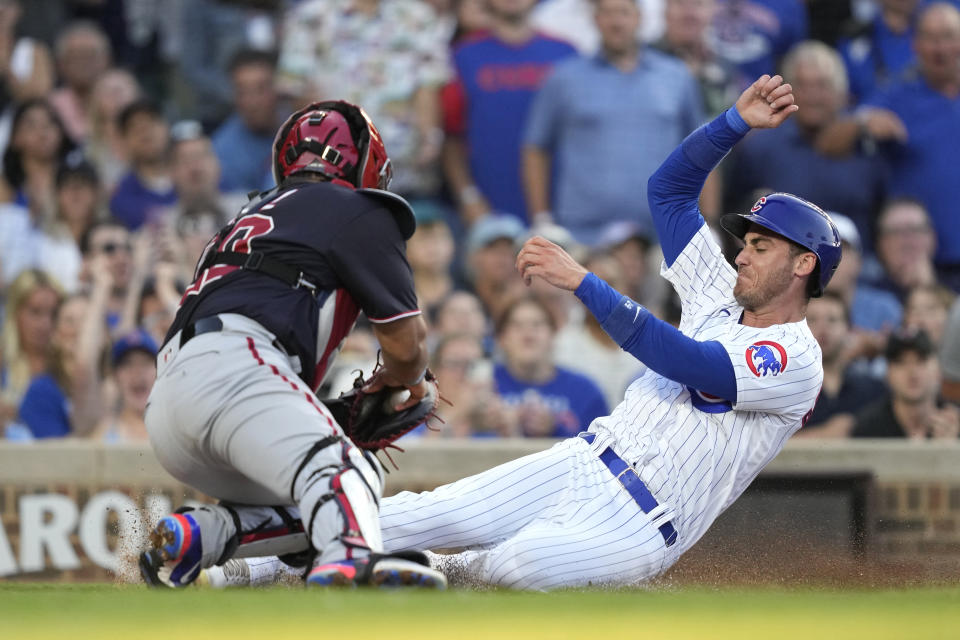 Chicago Cubs' Cody Bellinger, right, scores past Washington Nationals catcher Keibert Ruiz, off Christopher Morel's single during the second inning of a baseball game Monday, July 17, 2023, in Chicago. (AP Photo/Charles Rex Arbogast)