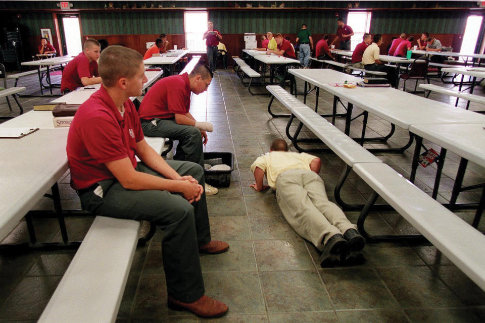 A student at Agapé Boarding School near Stockton, Missouri, performs push ups when his student guide ruled his clean up work was not good enough in September 2002.