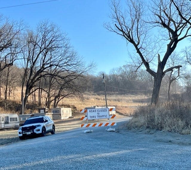 A Fremont County sheriff's deputy blocks access to Green Hollow Road near the southwest Iowa town of Thurman. Authorities are said to be digging on a site on the road, looking for remains of victims of an alleged serial killer who lived there.