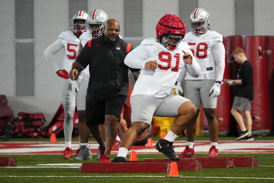 Defensive lineman Tyleik Williams runs drills under the watchful eye of his position coach Larry Johnson.