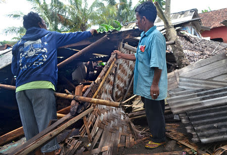 Residents collect debris from their collapsed house after it was hit by a tsunami at Panimbang district in Pandeglang, Banten province, Indonesia, December 23, 2018, in this photo taken by Antara Foto. Antara Foto/Muhammad Bagus Khoirunas/ via REUTERS