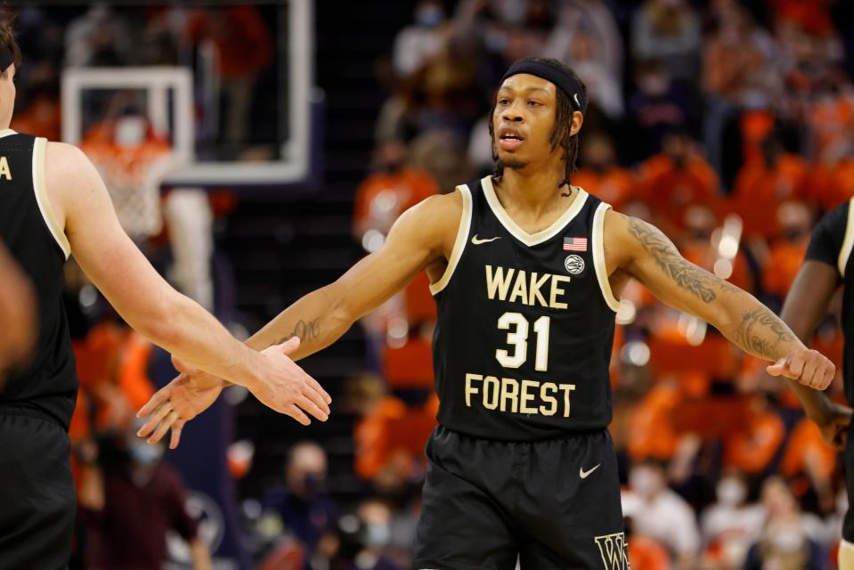 Alondes Williams celebrates with Wake Forest teammate Jake LaRavia, left, during the Demon Deacons’ victory last weekend at Virginia.