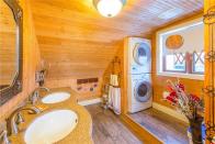 <p>The master bathroom is also covered in wood, and has a built-in washer/dryer station. </p>