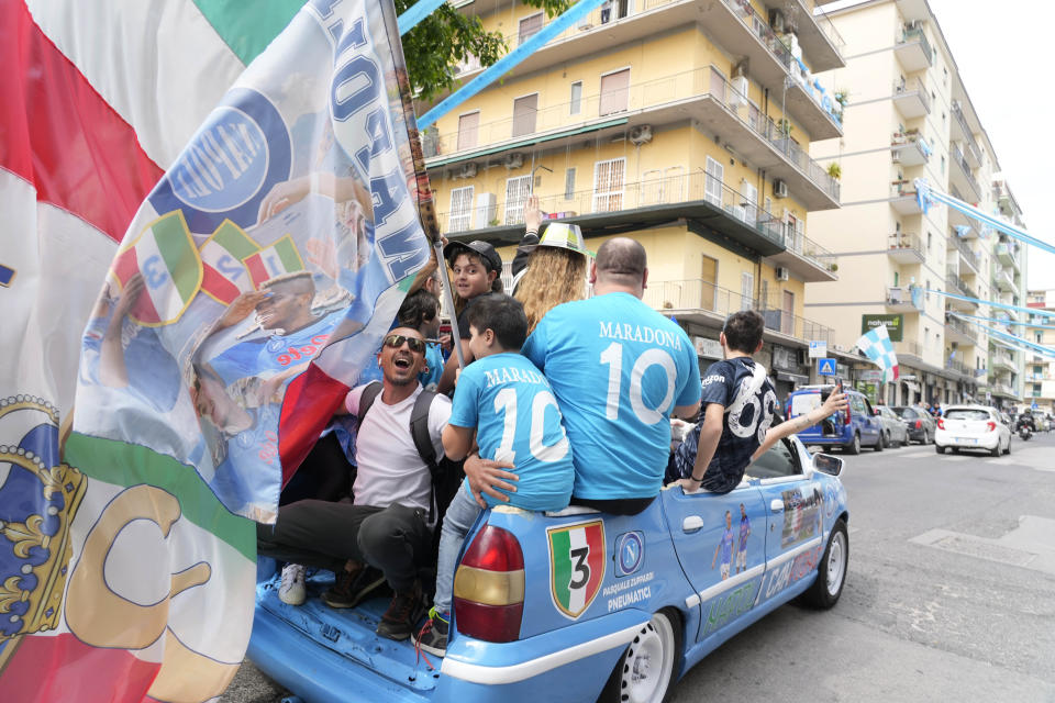 Napoli fans celebrate outside the Diego Maradona stadium in Naples, Italy, Sunday, April 30, 2023. After Napoli's game was moved to Sunday, the team could secure the title in front of their own fans by beating Salernitana — if Lazio fails to win at Inter Milan earlier in the day. Diego Maradona led Napoli to its only previous Serie A titles in 1987 and 1990. (AP Photo/Gregorio Borgia)