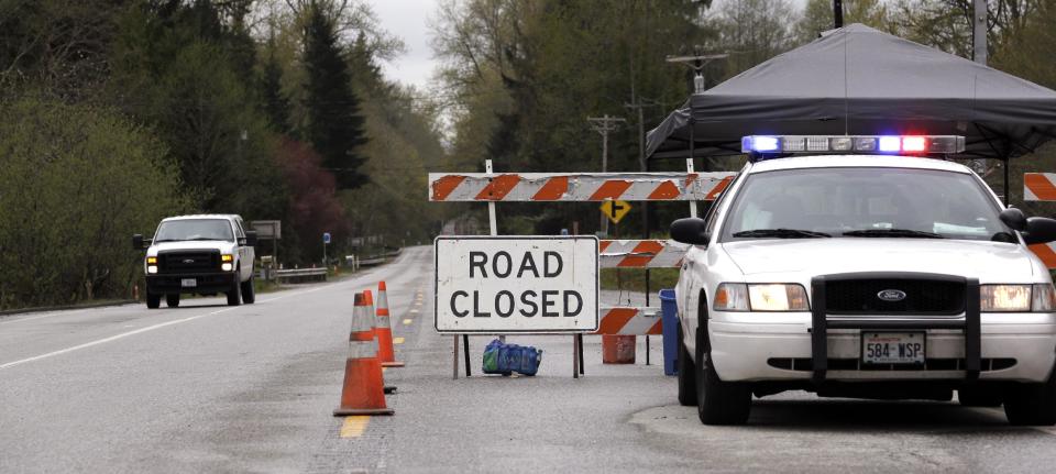 A Washington State Patrol vehicle staffs the closure westbound of Highway 530, Tuesday, April 15, 2014, near Darrington, Wash. One more victim has been recovered from the mudslide that hit the nearby town of Oso, Wash., March 22, raising the death toll to 37, the Snohomish County medical examiner's office said Tuesday. Seven people remain on the missing list, the sheriff's office said. (AP Photo/Elaine Thompson)