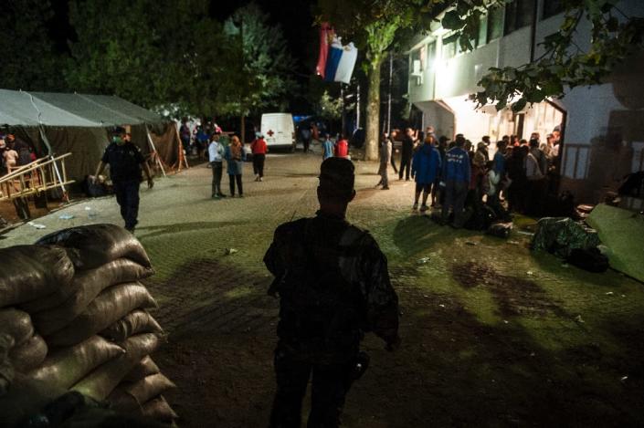 A Serbian military policeman stands guard as migrants wait to be registered in a camp in the southern Serbian town of Presevo, August 23, 2015 (AFP Photo/Armend Nimani)