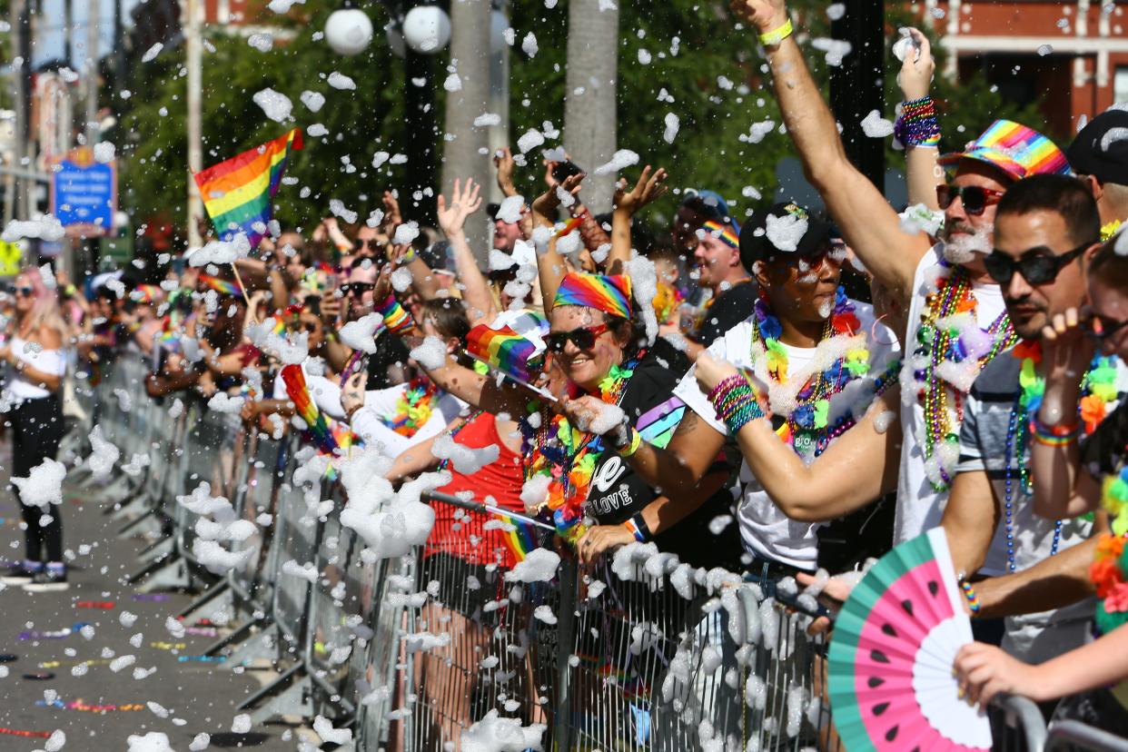 Smiling faces and bright colors are seen behind a wall of bubbles and foam being sprayed to the crowd during the Tampa Pride Diversity Parade, on Saturday, May 22, 2021 in Ybor City, Florida. (Luis Santana/Tampa Bay Times via ZUMA Wire)