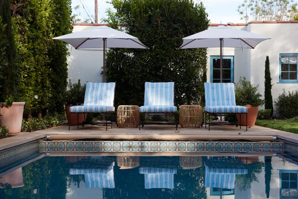Chaises by Janus et Cie, umbrellas from RH, and side tables from Serena & Lily define the pool area.