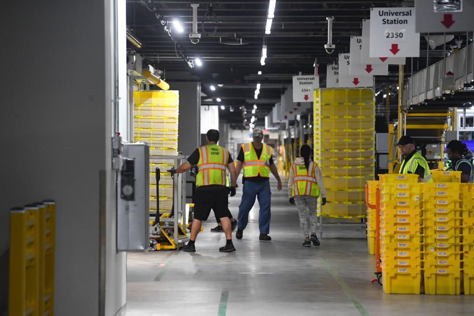 Workers move pods of goods inside the new Amazon Fulfillment Center on Thursday, October 13, 2022, in Sioux Falls.