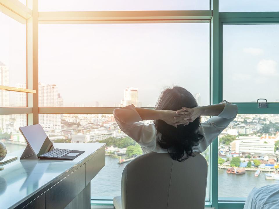 a woman reclines in a chair at her desk