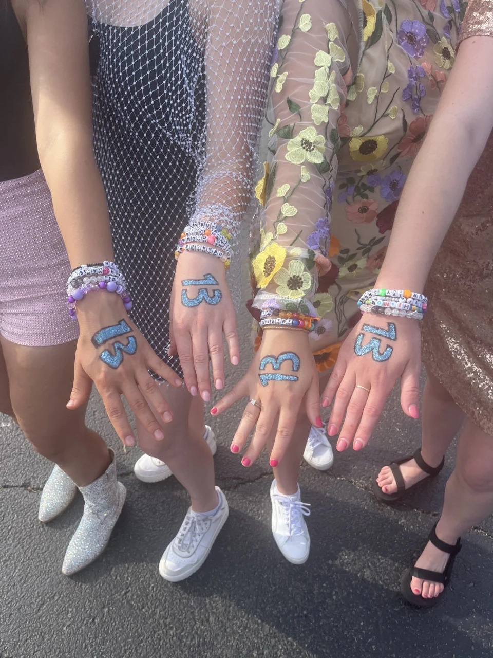 Madeline Mitchell and friends wrote Swift's lucky number, 13, on their hands in sparkly blue and wore friendship bracelets for The Eras Tour in Chicago.