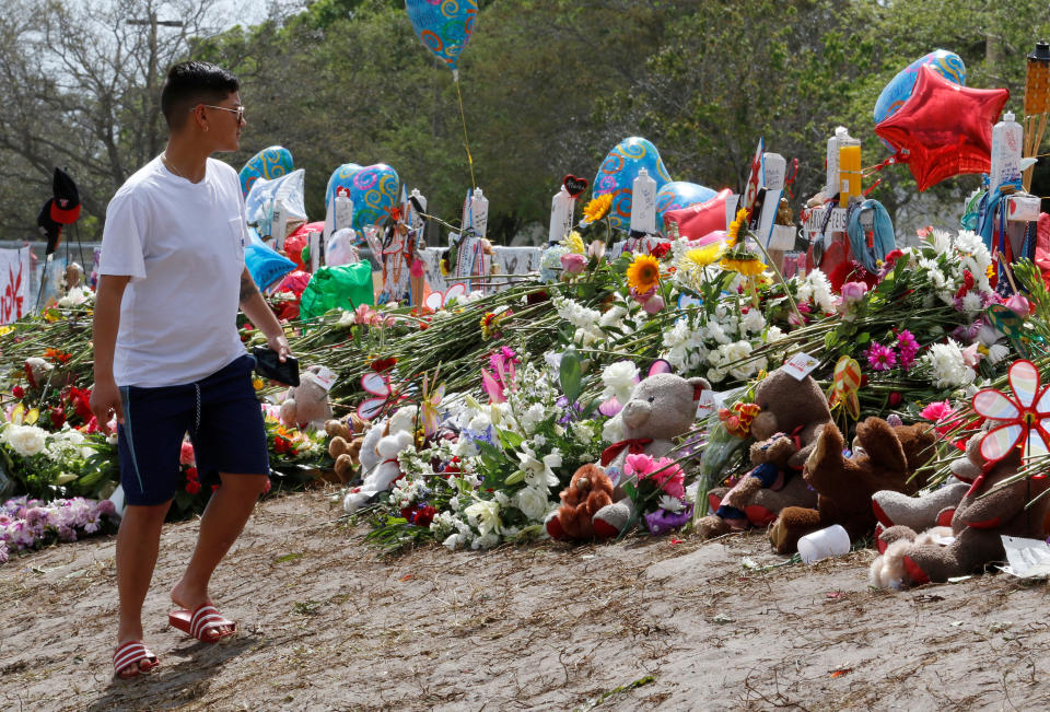 A young man views memorials on a fence surrounding Marjory Stoneman Douglas High School in Parkland, Florida, U.S., February 23, 2018. (Photo: Joe Skipper / Reuters)