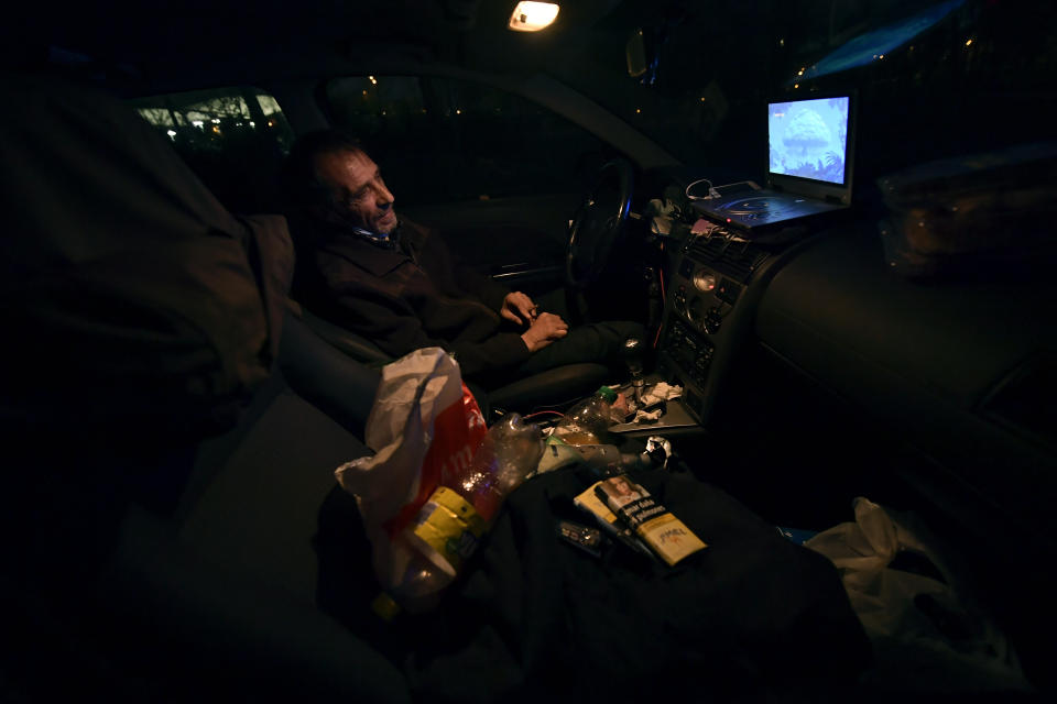 Juan Jimenez, 60, sits in his car which is now his home, in Pamplona, northern Spain, Tuesday, March 17, 2021. Jimenez has been forced to dwell in his second-hand Ford for close to a year after seeing his life collapse when he and his wife bought a bigger house, only for mortgage payments to spiral out of control and for their marriage to crumble after the economic slowdown caused by the coronavirus pandemic destroyed his financial stability. (AP Photo/Alvaro Barrientos)