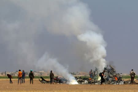 Men inspect the wreckage of a Russian helicopter that had been shot down in the north of Syria's rebel-held Idlib province, Syria August 1, 2016. REUTERS/Ammar Abdullah