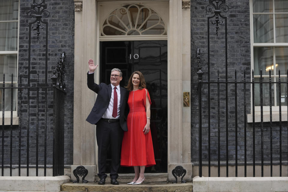 El primer ministro del Reino Unido, Keir Starmer, por el Partido Laborista, y su esposa Victoria saludan a sus partidarios y reporteros desde la entrada de la residencia oficial en 10 Downing Street de Londres, el viernes 5 de julio de 2024. (AP Foto/Kin Cheung)