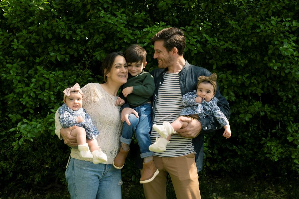 Randa Samaha and Zachary Madrigal pose with their 2-year-old son and twin 6-month-old girls.