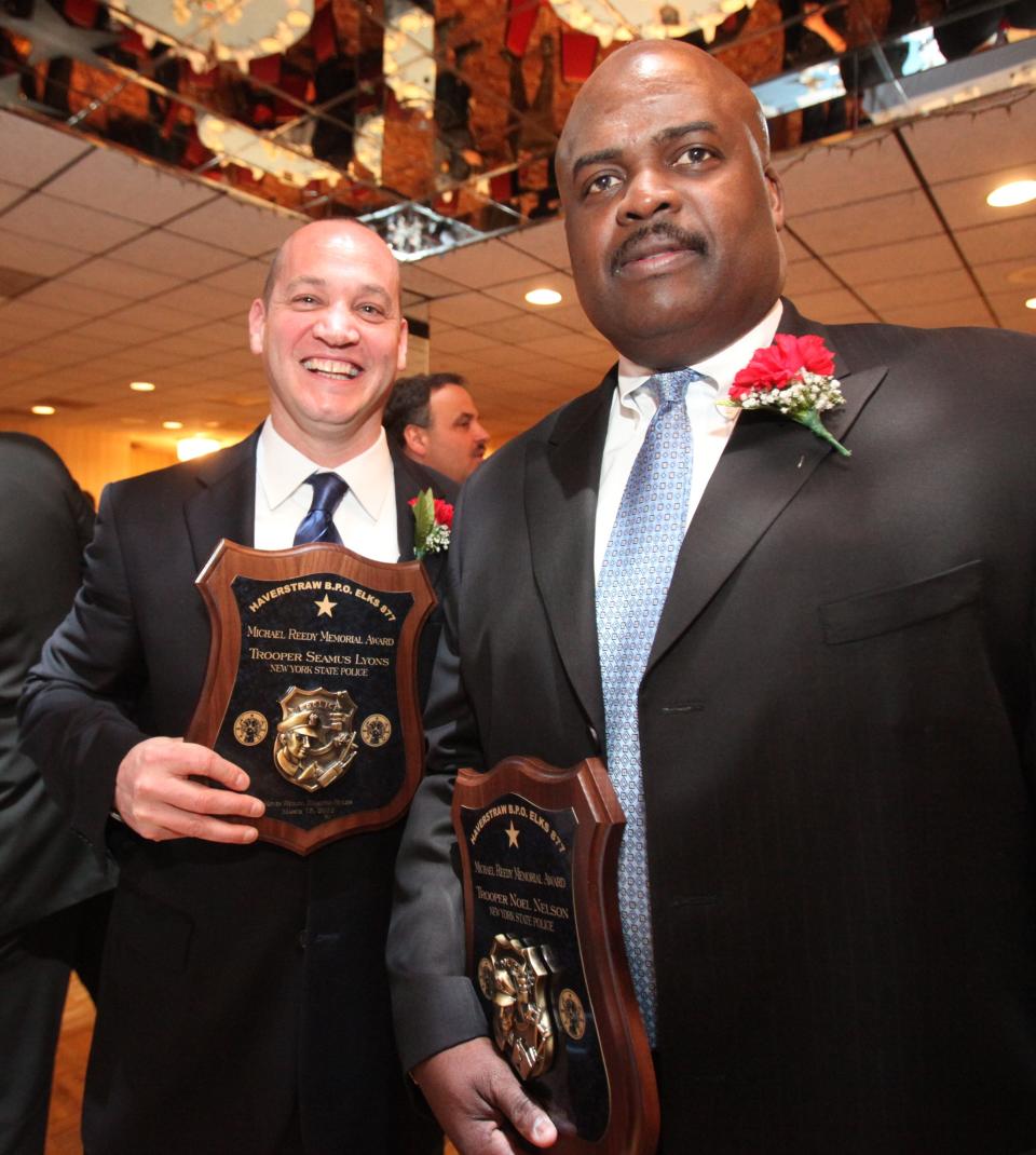 Former New York State Police Troopers Seamus Lyons, left, and Noel Nelson, right, hold plaques during awards ceremonies at the Haverstraw Elks Club in 2012. The two filed a federal civil rights lawsuit against the department onTuesday, May 12, 2015, claiming discrimination and that they were scapegoated for missing evidence from Troop K barracks in Hawthorne.