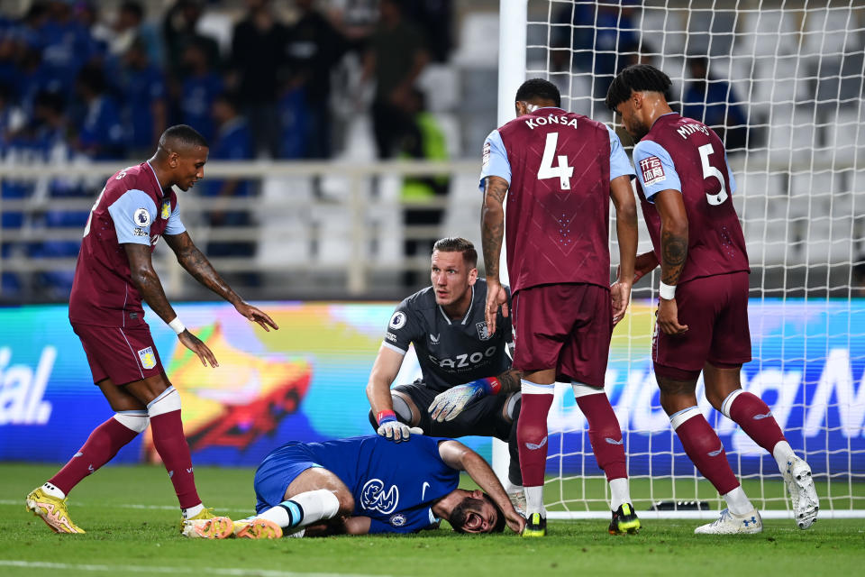 ABU DHABI, UNITED ARAB EMIRATES - DECEMBER 11: Armando Broja of Chelsea holds their leg, as teammates and players of Aston Villa offer support, during the Al Wahda Challenge Cup match between Chelsea and Aston Villa at Al Nahyan Stadium on December 11, 2022 in Abu Dhabi, United Arab Emirates. (Photo by Darren Walsh/Chelsea FC via Getty Images)