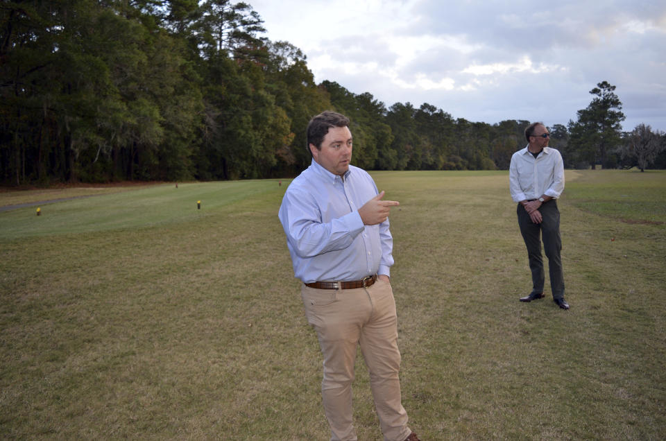 Jay Revell, left, who serves as the historian for the Capital City Country Club, visits the 7th hole of the country club on Dec. 16, 2019, with Jeffrey Shanks, right, an archaeologist with the National Park Service in Tallahassee, Fla. . Revell says the country club’s board is considering how to memorialize dozens of slaves buried in an unmarked cemetery near the 7th hole women’s tee. The golf course is located on land that was once one a former plantation. (AP Photo/Bobby Caina Calvan)