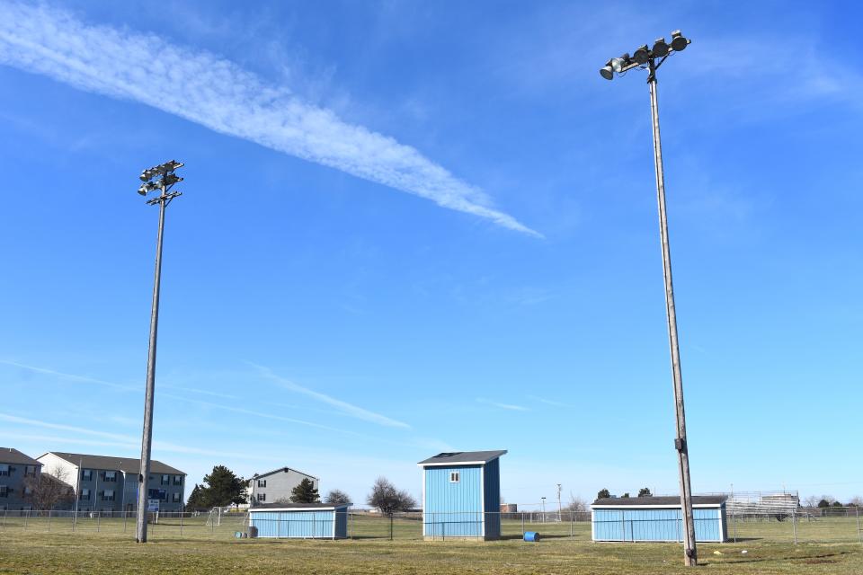 Two of the eight light poles and fixtures currently standing around the former Adrian Public Schools baseball field near Division Street and Maple Stadium are pictured in this April 12 file photo. The Adrian Board of Education has approved a project to take down these poles and replace them and the lights on them,