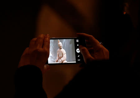 A visitor photographs a Terracotta Warrior which guarded the tomb of China’s First Emperor, Qin Shi Huang, on loan from China as it is displayed in The World Museum, Liverpool, Britain February 6, 2017.REUTERS/Andrew Yates