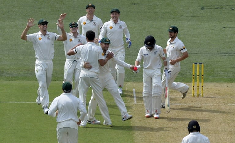 Australia's players celebrates the wicket of New Zealand's Kane Williamson (R) off paceman Mitchell Starc during the first day-night Test match at the Adelaide Oval on November 27, 2015