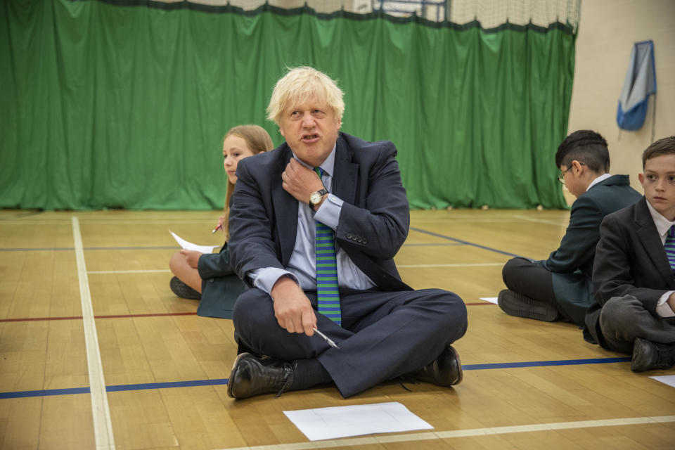 Prime Minister Boris Johnson with Olivia Stokes in the gym taking part in a getting to know you induction session with year sevens as he tours Castle Rock school, Coalville, in the east Midlands.