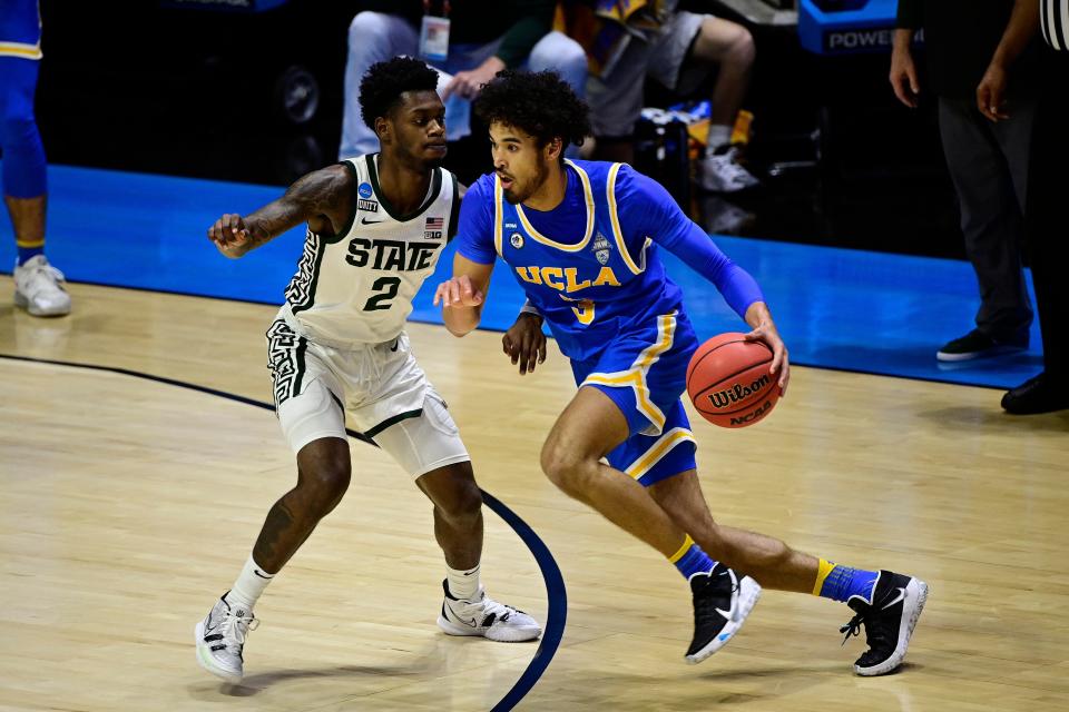 UCLA guard Johnny Juzang drives against Michigan State guard Rocket Watts (2) in the first half during the First Four of the 2021 NCAA tournament at Mackey Arena.