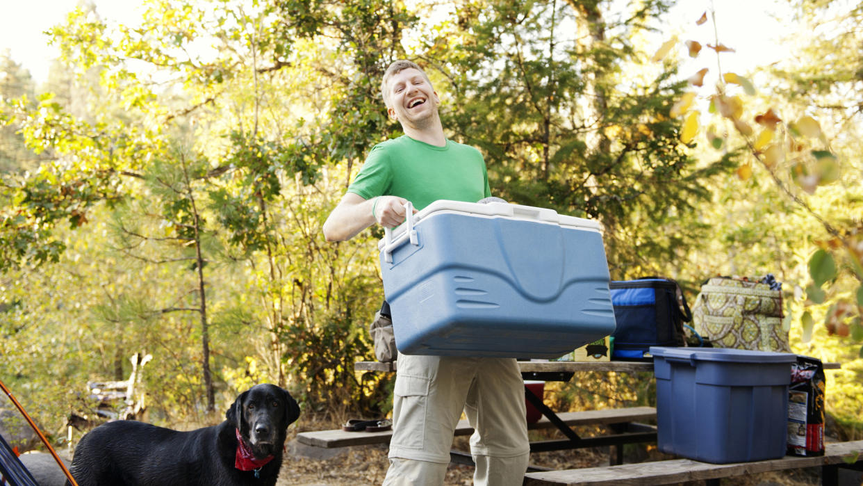  How to store food while camping: man with cool boxes. 