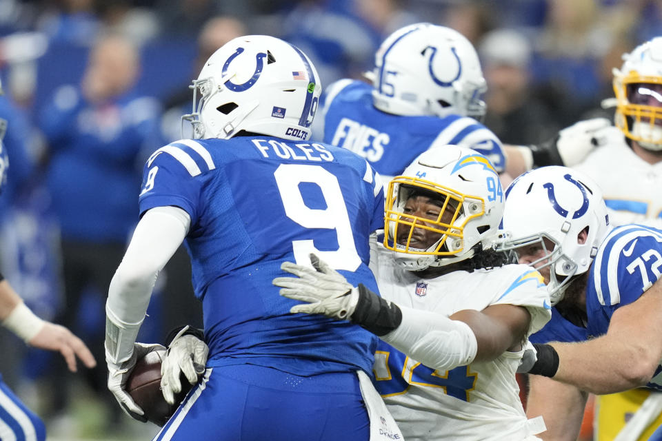 Los Angeles Chargers' Chris Rumph II (94) sacks Indianapolis Colts quarterback Nick Foles (9) during the second half of an NFL football game, Monday, Dec. 26, 2022, in Indianapolis. (AP Photo/Michael Conroy)